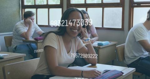 Smiling student leaning on hand in bright classroom with open notebook and pencil case