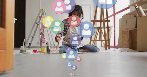 Artist painting on floor with colorful digital network icons