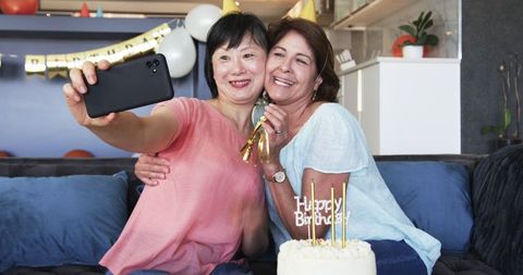 Senior Female Friends Celebrating Birthday with Selfies at Home