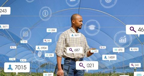 Agritech technician monitoring polytunnel crops with tablet and smartphone using analytics