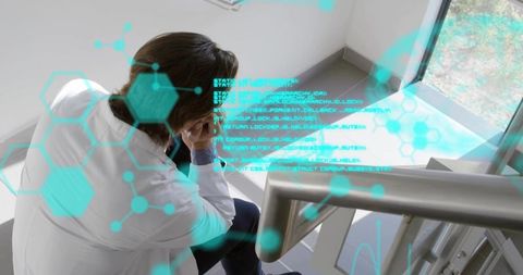Medical researcher experiencing burnout on staircase with futuristic cyan data holograms