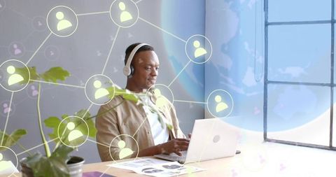 Remote collaboration and focus: professional using laptop and headphones in bright workspace