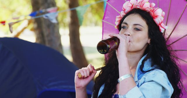 Young Woman Enjoying Beverage at Outdoor Festival with Umbrella - Download Free Stock Images Pikwizard.com