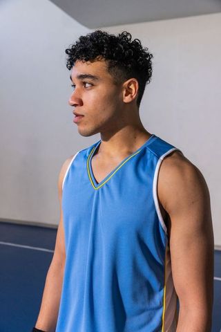 Young Athlete Standing on Gymnasium Court Ready for Game