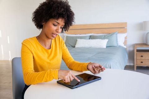African american woman using tablet in stylish bedroom