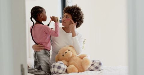 Mother and Daughter Bonding on Bed with Teddy and Makeup