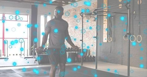 Athlete skipping rope in urban gym with functional rig and gymnastic rings