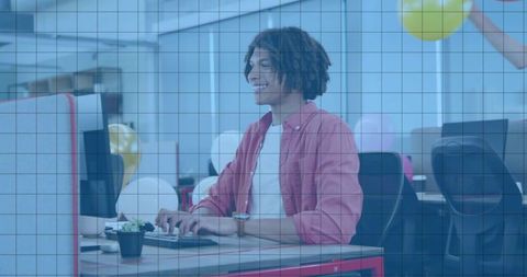Young Professional Typing at Festive Open-Plan Office Desk with Balloons and Succulent