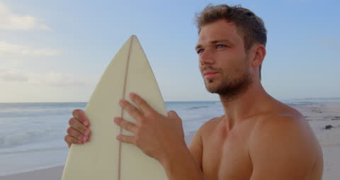 Pensive Surfer Gazing at Ocean with Surfboard