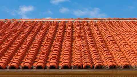 Sunlit Terracotta Roof Tile Footage Showing Repeating Curved Clay Rows and Moving Clouds