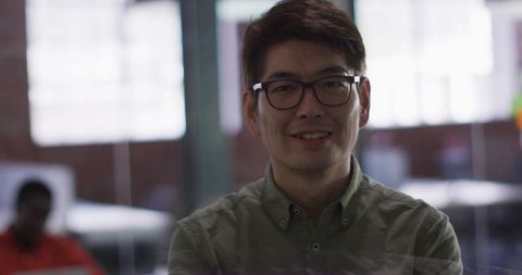 Confident Asian Professional Wearing Glasses in Modern Office Environment