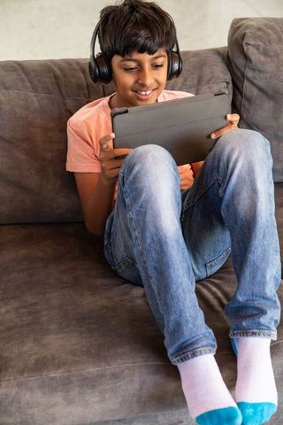 Young boy relaxing at home engaged with tablet