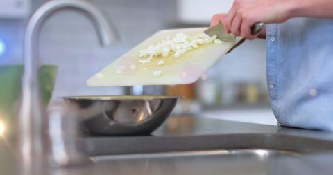 Man Chopping Onions in Modern Kitchen