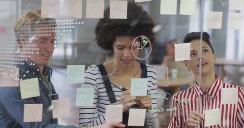 Diverse Team Collaborating on Project with Sticky Notes and Diagrams