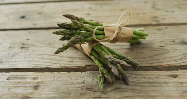 Image of two fresh asparagus bundles on wooden background. fusion food, fresh vegetables and healthy eating concept.