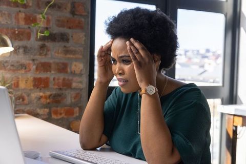 Mid-adult African American Woman Focused on Laptop in Contemporary Office