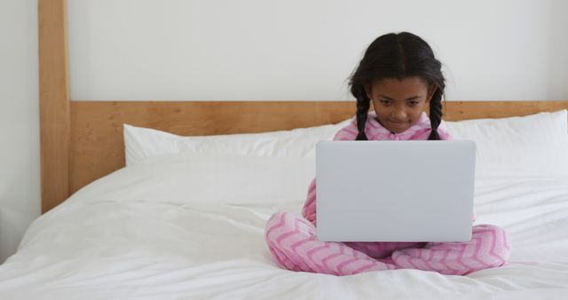 Young Girl in Pajamas Using Laptop on Bed - Download Free Stock Images Pikwizard.com