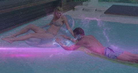 Couple Relaxing in Backyard Pool Under Starry Overlay Effect