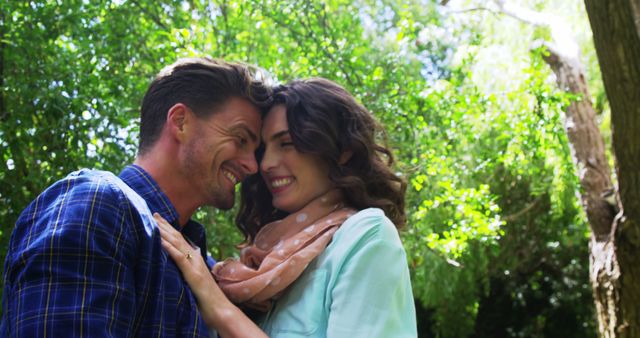 A Caucasian couple enjoys a romantic moment outdoors, with copy space. Their affectionate embrace and joyful expressions convey a sense of love and happiness.