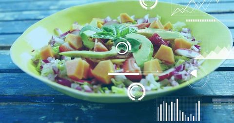 Fresh avocado mango salad with basil and data visualization overlays on rustic blue table