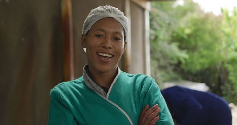 Smiling organic farmer on sustainable farm with crossed arms