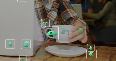 Sipping coffee while working on laptop with green sustainability icons overlay in cafe