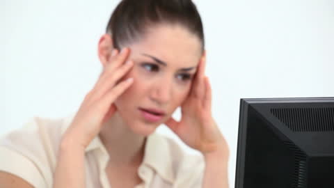 Stressed Woman at Office Desk Looking at Computer