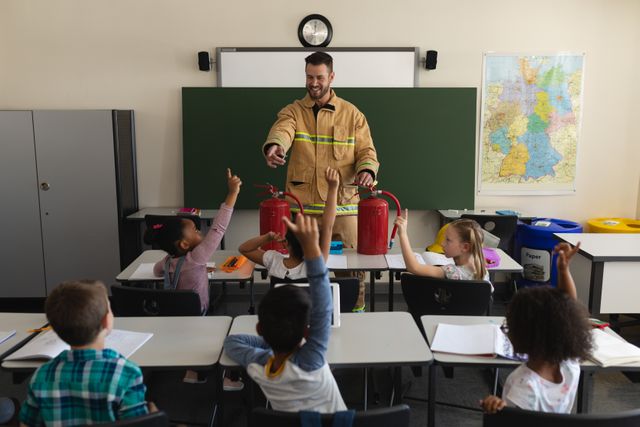 Firefighter engaging with elementary school children, teaching them about fire safety. Ideal for use in educational materials, safety training programs, school brochures, and community awareness campaigns.