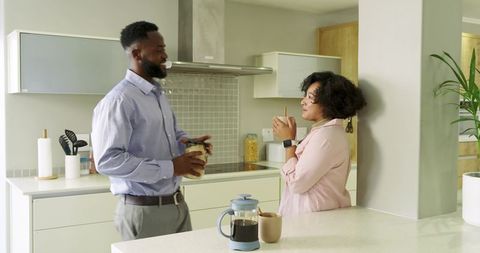 Diverse couple brewing French press coffee and chatting at modern kitchen island