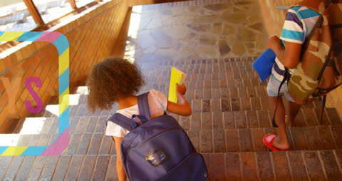 Diverse Schoolchildren Descending Staircase with Backpacks