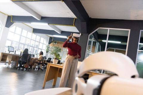 Diverse team testing virtual reality headsets in modern sunlit coworking loft workspace