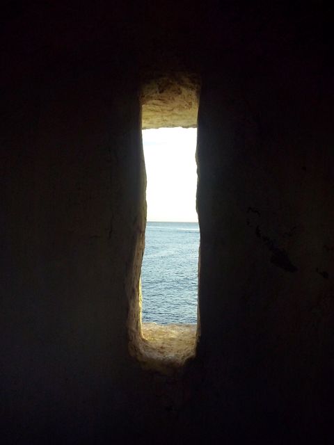 Sunlit Ocean View Through Narrow Stone Window - Download Free Stock Photos Pikwizard.com