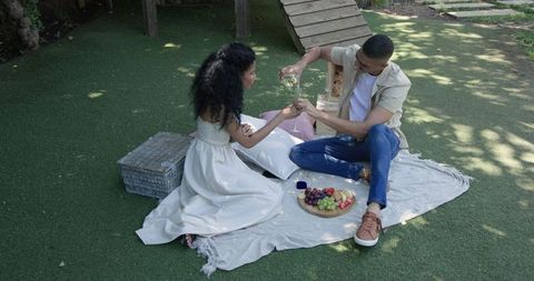 Couple Enjoying Picnic with Wine and Fruits on Sunny Day