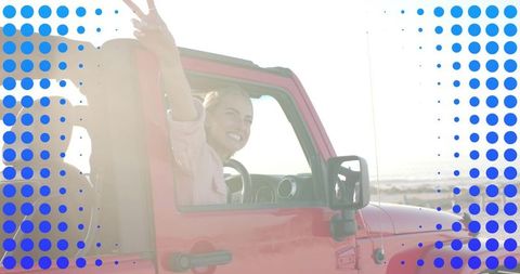 Carefree young woman enjoying coastal adventure in red jeep