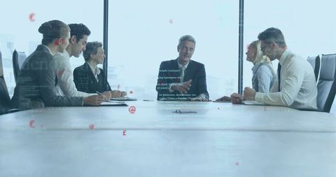 Executive leading boardroom meeting gesturing while presenting strategy to leadership team