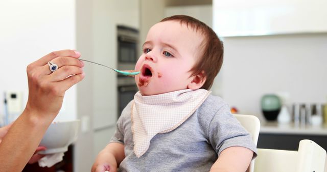 Mother Feeding Baby with Spoon in Bright Kitchen Setting - Download Free Stock Images Pikwizard.com