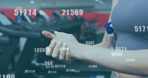 Woman applying hand sanitizer at gym workout session