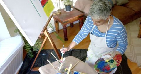 Creative Senior Woman Painting at Home Workshop in Daylight