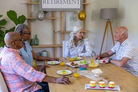 Diverse seniors celebrating retirement with dining and conversation