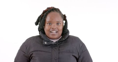Smiling woman in black winter coat against white background