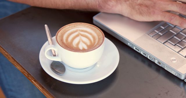 Coffee Latte with Leaf Art Next to Typing Hands on Laptop - Download Free Stock Images Pikwizard.com