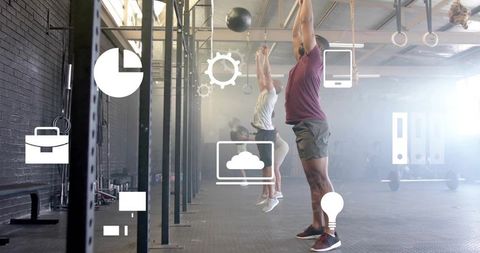 CrossFit athletes performing medicine ball throws in industrial gym with business icons