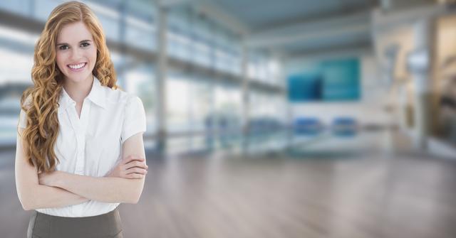 Confident businesswoman with arms crossed, smiling while standing in modern office. Suitable for depicting business leadership, workplace environment, professional success, and career advancement themes. Useful in corporate websites, professional blogs, business-related articles, and career development content.