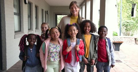 Cheerful Teacher Guiding Students on Colorful Outdoor School Walkway