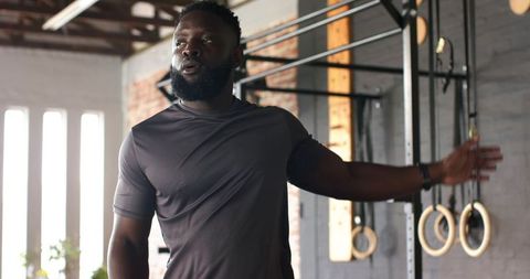 Motivated Athlete Near Pull-Up Rig in Gym Setting