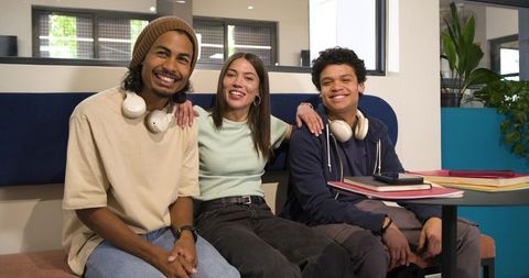 African american students and friends smiling, studying and collaborating in modern campus lounge