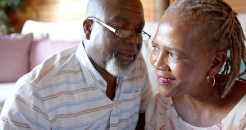 Elderly Couple Sharing a Warm Moment on Sofa in Living Room