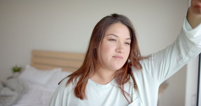 Young woman waking up in bed with peaceful morning light - Download Free Stock Images Pikwizard.com