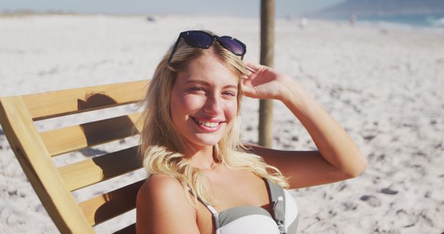 Portrait of happy caucasian woman sitting on deckchair on beach - Download Free Stock Photos Pikwizard.com