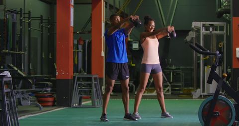 Couple Engaging in Kettlebell Workout at Gym